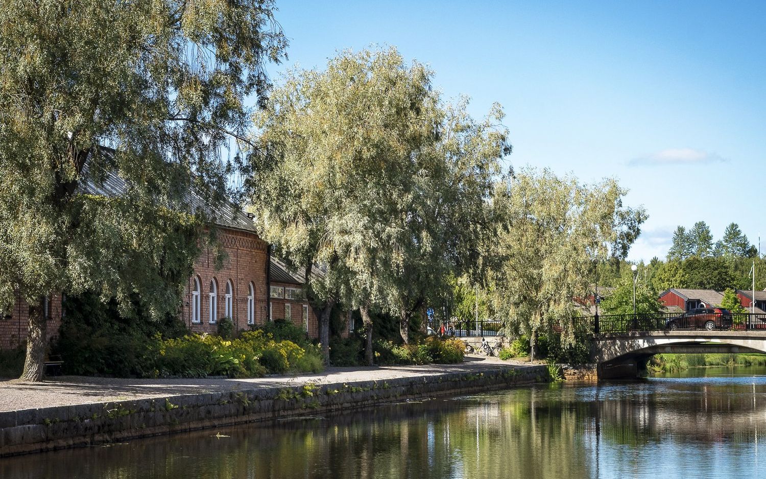 Centrala Falun med äldre tegelbyggnad och pilträd vid vattnet